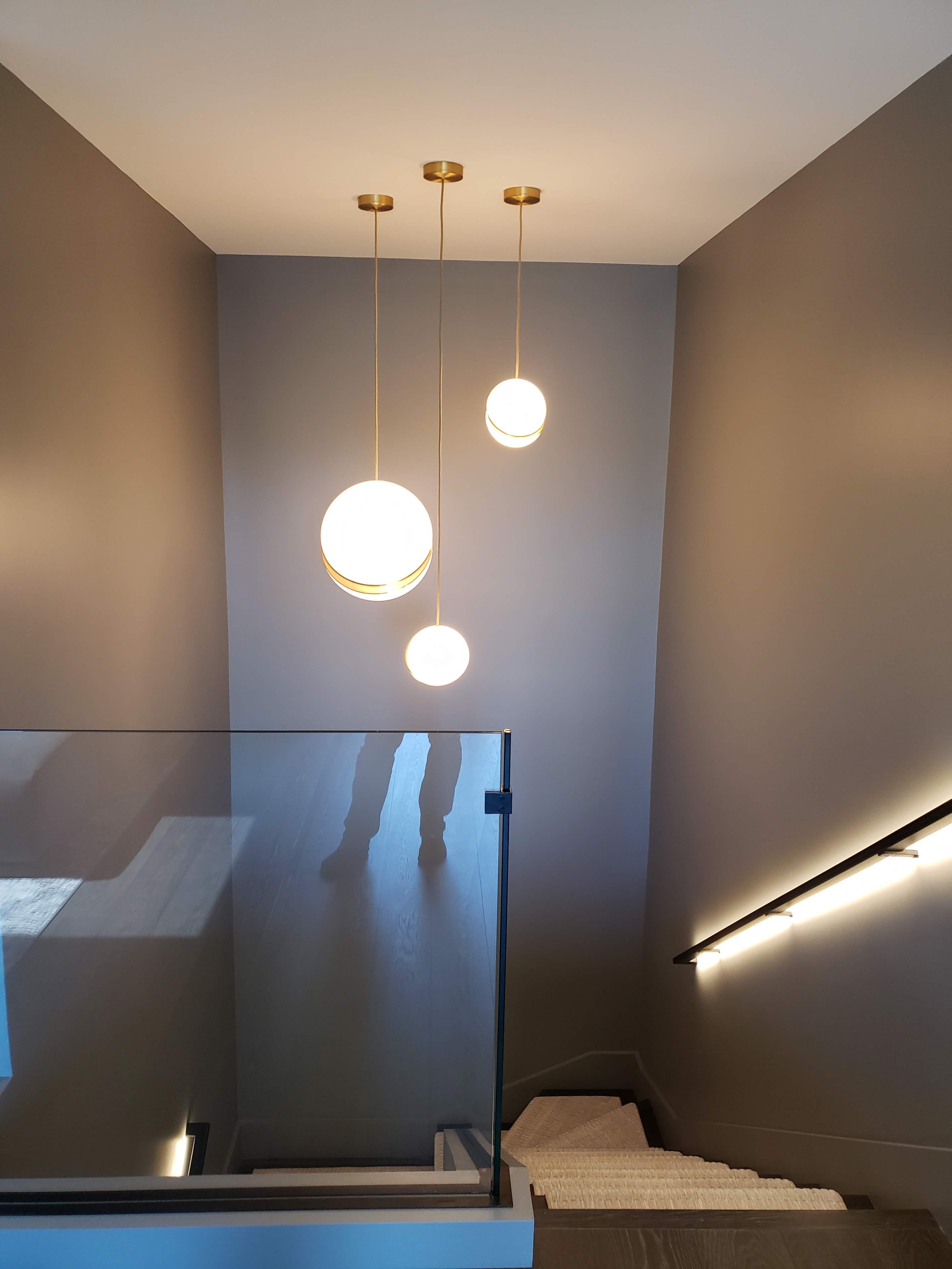 Pendant fixtures and integrated stair lighting in a Hampstead residence